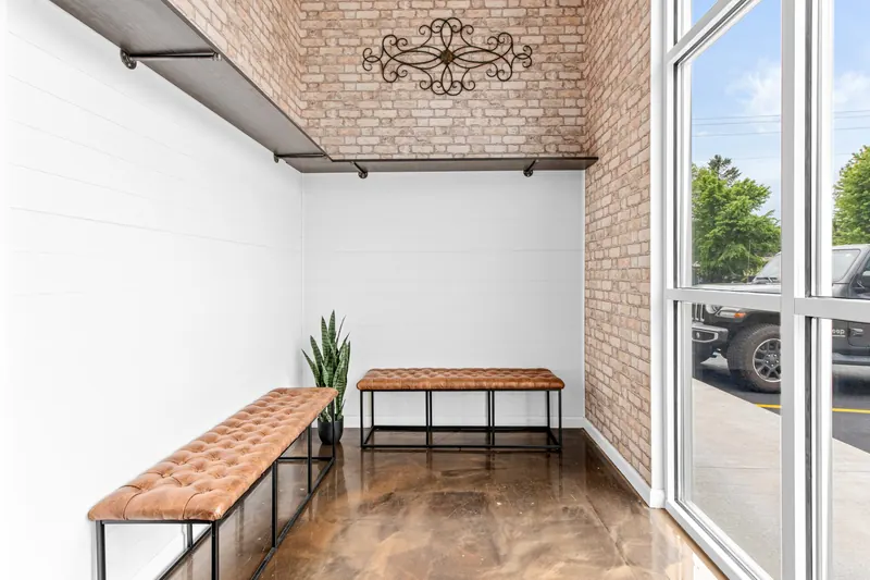 Entry alcove with tufted leather benches against brick