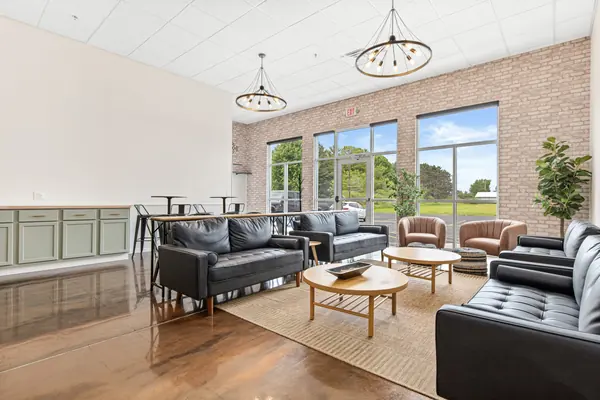 Wide view of the lounge with accent chairs, windows and kitchenette cabinets
