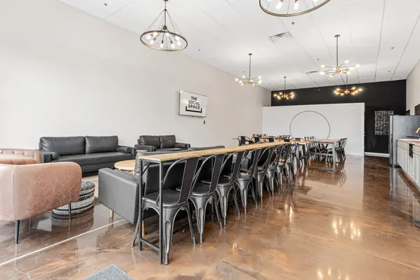 Long table with chairs running toward the ring wall, sofas at left