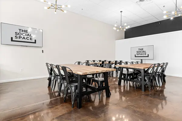 Two long tables and two TVs, set up meeting-style