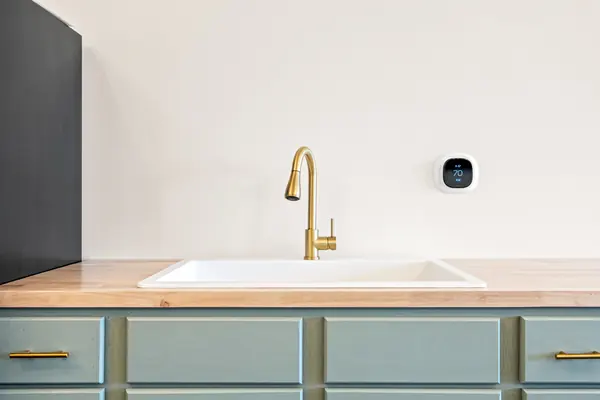 Close-up of the white sink and brass faucet